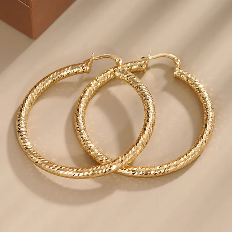 A pair of geometric design clip-on earrings for women with a drop shape and ring-and-line details.