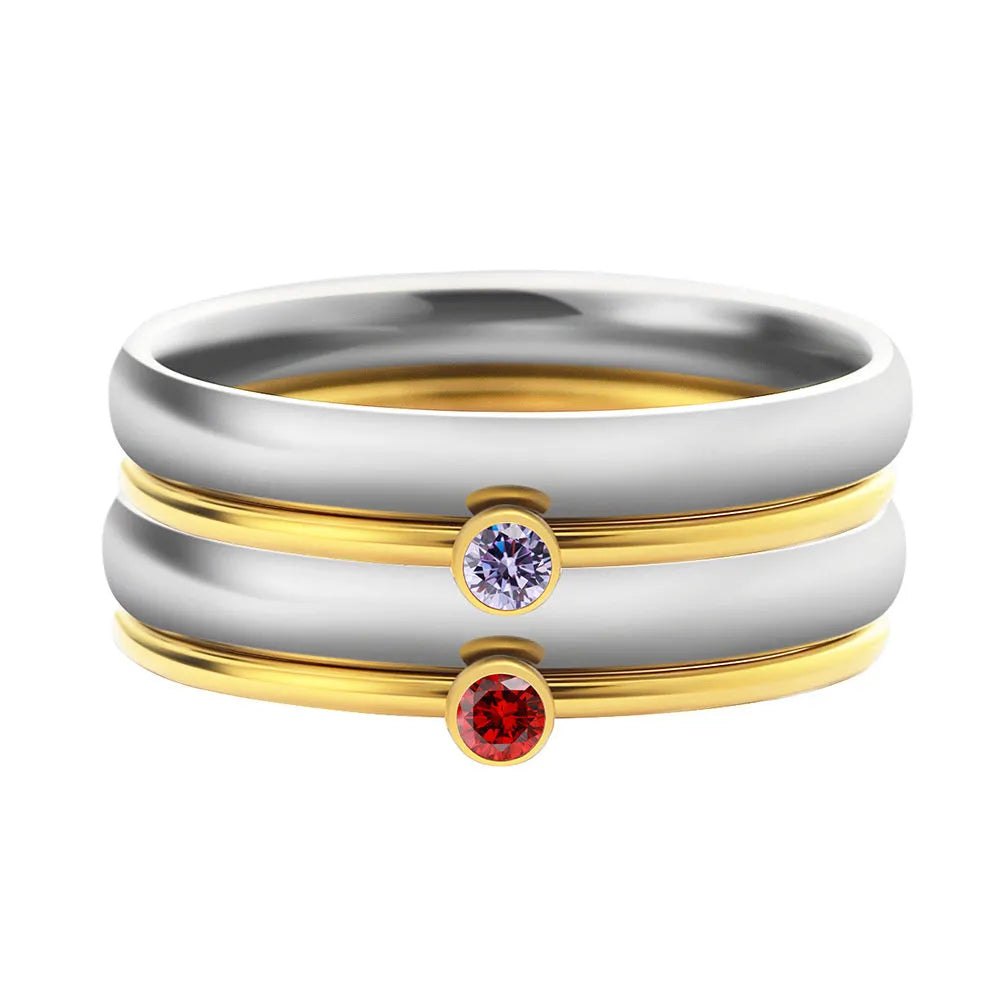 A geometric titanium steel ring with a December birthstone and gold-coloured handle on a plain background.