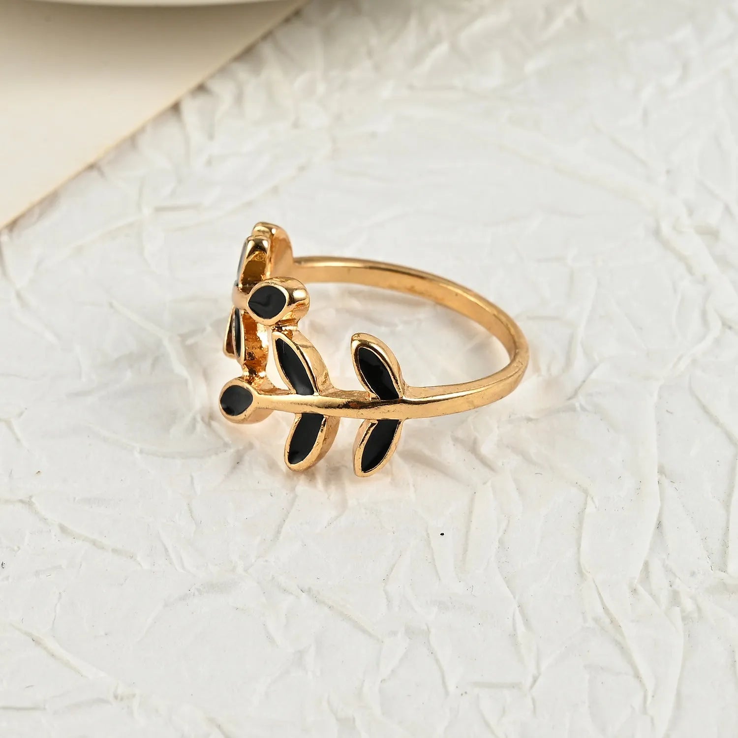 Gold-coloured acrylic ring with a floral shape and leaf geometric design details.