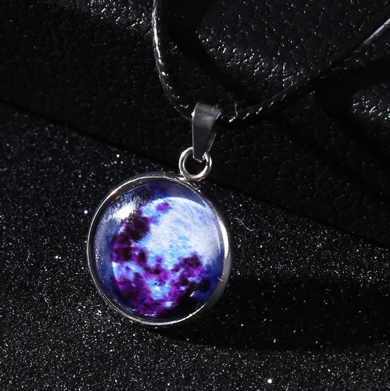 Luminous moon and star constellation pendant necklace with a silver-tone chain on a black background.
