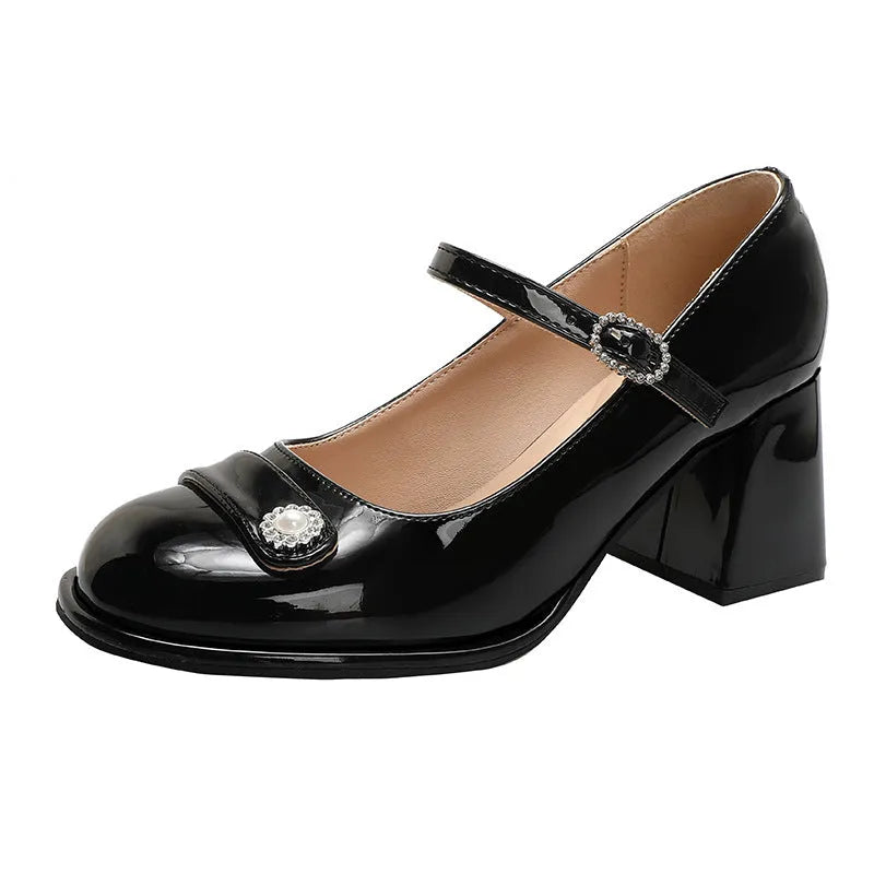 Women's black patent leather chunky heel shoes with a round toe and buckle fastening.