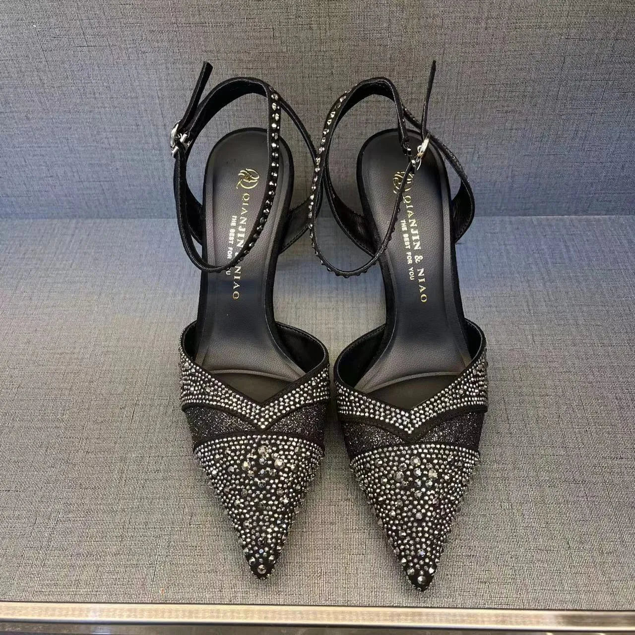 Women's black and silver hollow-cut stiletto heels with a pointed toe and shallow mouth design.