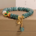 Blue water jade bead bracelet with white agate abacus beads and a butterfly charm.