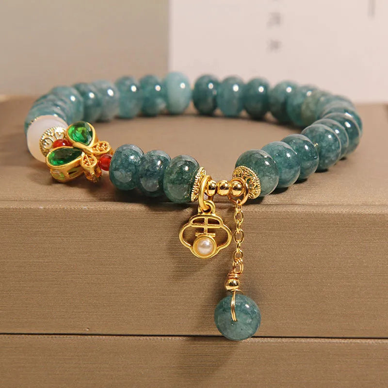 Blue water jade bead bracelet with white agate abacus beads and a butterfly charm.