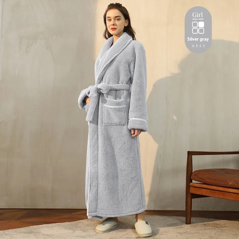 A man and woman wearing matching navy blue thick flannel bathrobes, showcasing the wrap-around design and plush fabric.