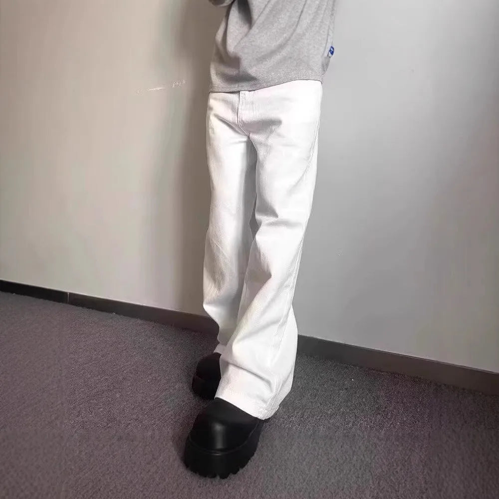 A man wearing white loose straight-leg cotton jeans with a mid-waist and zipper fly.