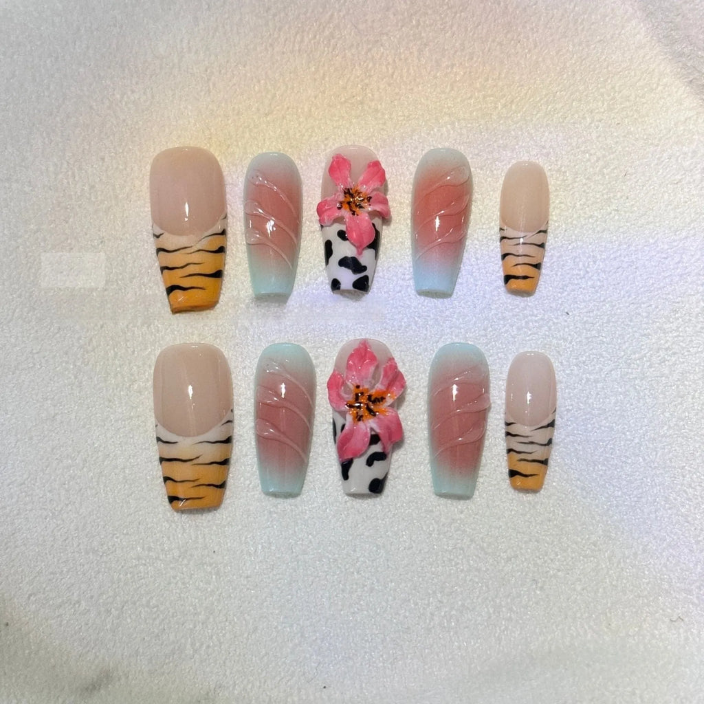 Hand-carved false nails with zebra pattern and lily designs in sizes XS through L
