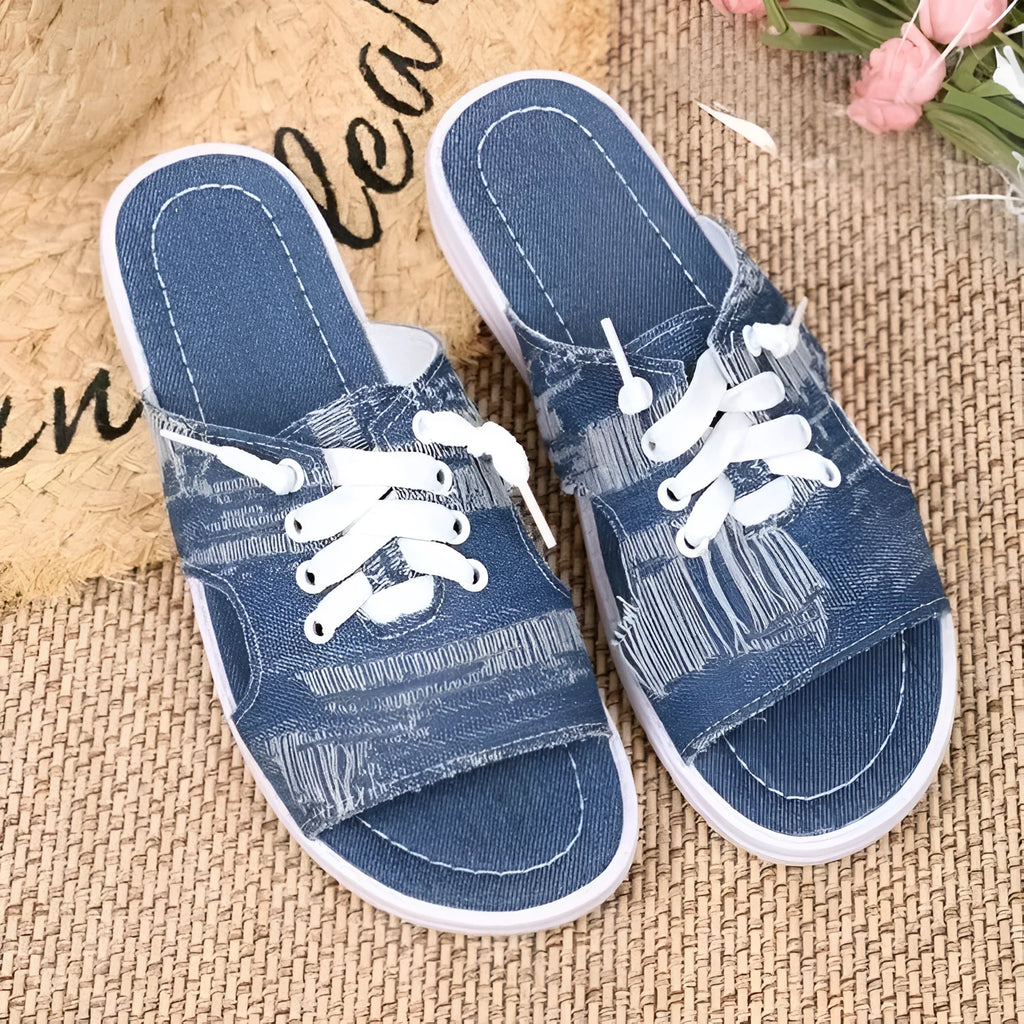 Blue Roman style women's flat canvas slippers with cloth upper and rubber sole.