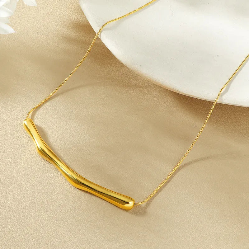 Close-up of a titanium steel women's necklace with an irregular pleated design in a gold electroplated finish.
