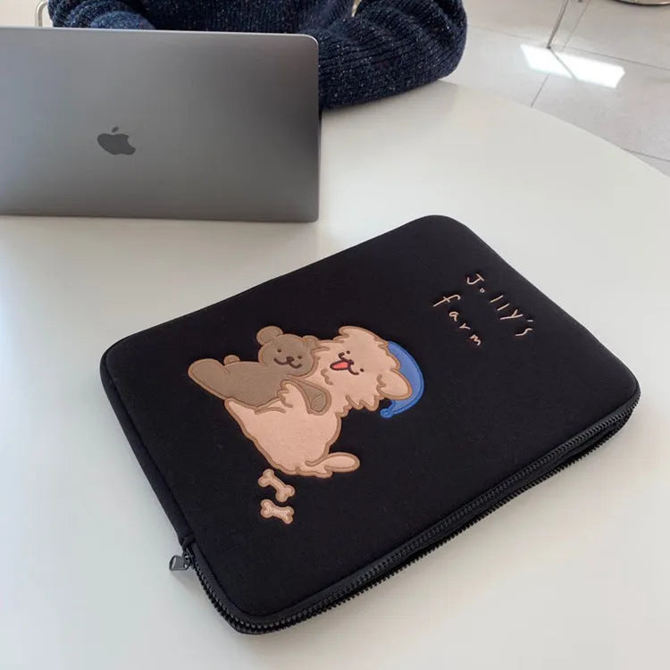 Embroidered animal design laptop sleeve in polyester, shown next to a laptop.