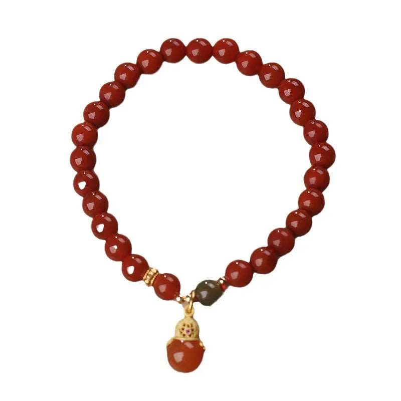 Red agate and Hetian jade bracelet with lucky beads pendant on display
