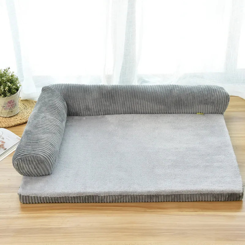 Grey corduroy dog sofa bed with raised sides and a non-slip base on a wooden floor.