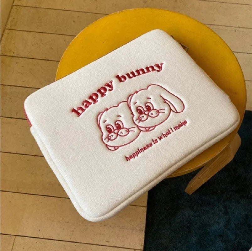 Embroidered animal design laptop sleeve in polyester, shown next to a laptop.