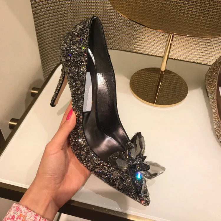 Gold women's stiletto heels with sequin upper, rhinestones, a bow, and a pointed toe.