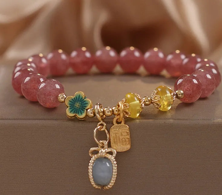 Red strawberry quartz beaded bracelet with metal alloy setting and sparkling rhinestone details.