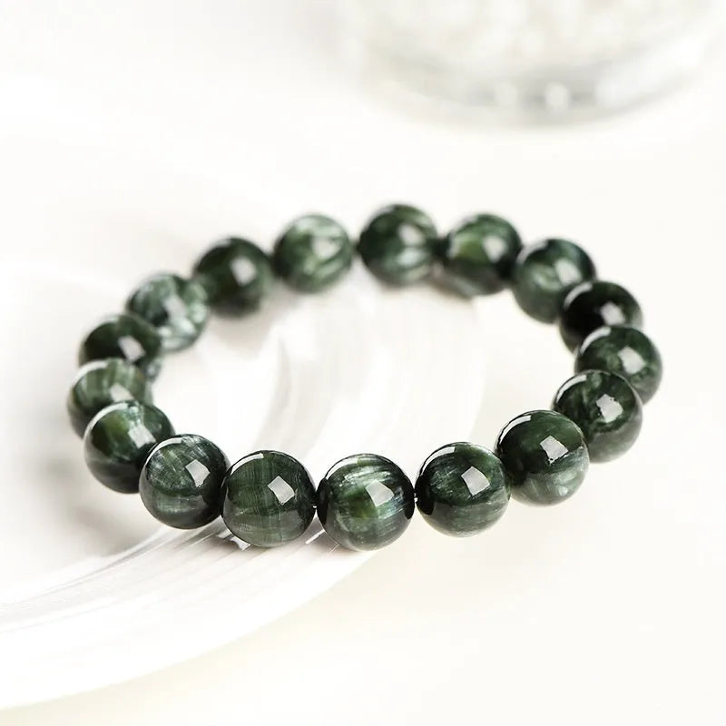 Grade 7A Green Dragon Crystal bracelet with round beads and ruyi design on a wrist.