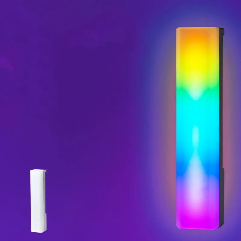 A tall, colourful RGB table lamp with a white or black shell reacting to sound on a desk.