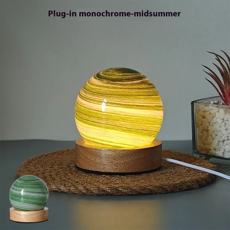 Modern planet-shaped USB night light on its base with dimmable multi-colour glow