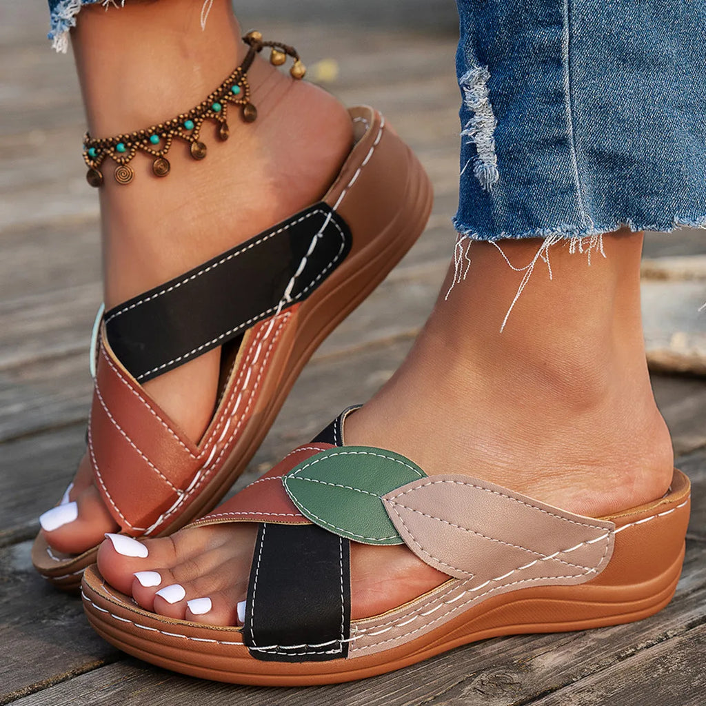 Women's black thick-soled slippers with a cross-strap and peep-toe design on a light background