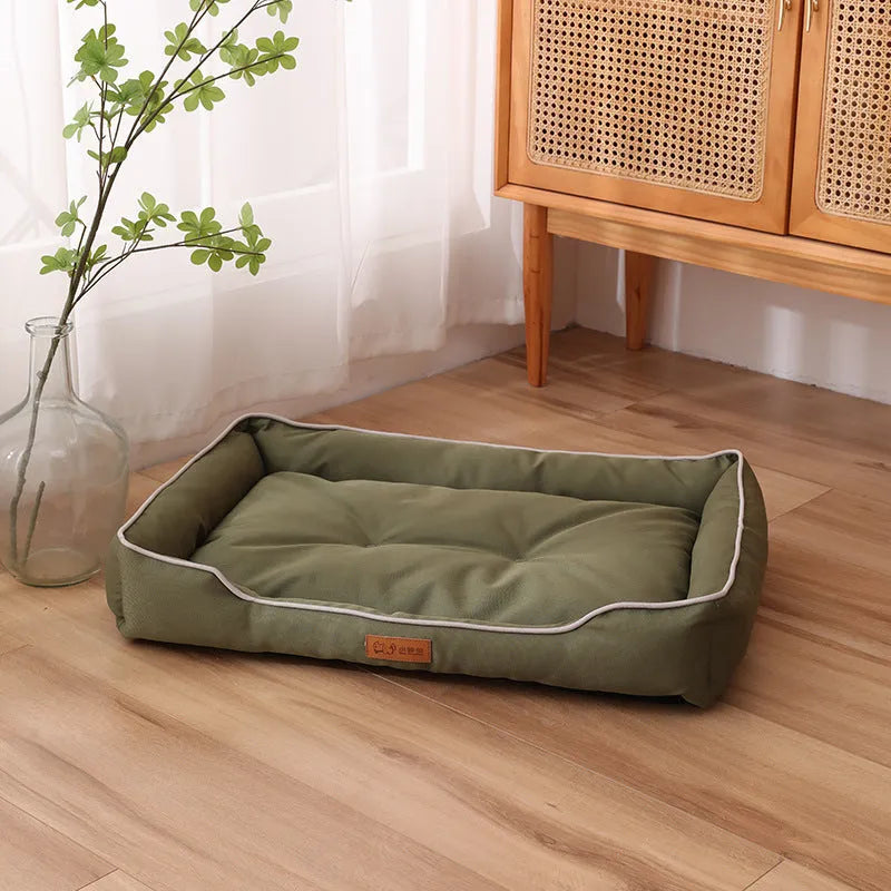 Grey waterproof dog sofa bed with raised edges on wooden floor
