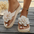 A pair of solid colour flip flop slippers with a small flower detail on the PU upper.