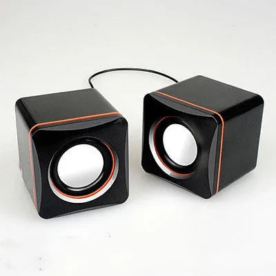 Small black square USB-powered 2.0 computer speaker on a desk.