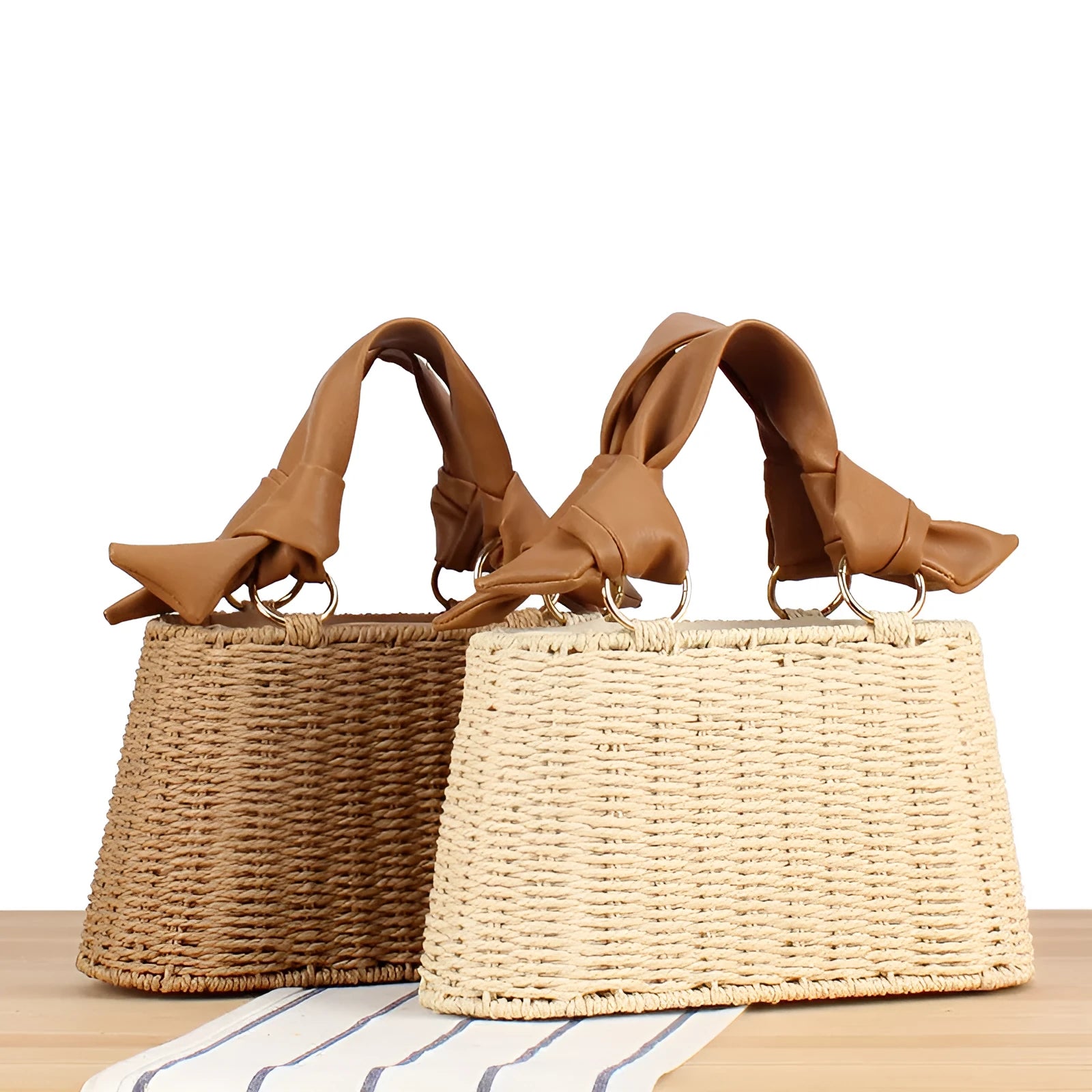 Portable woven straw bag in beige with hard trapezoid shape and double shoulder straps for seaside vacation daily use.