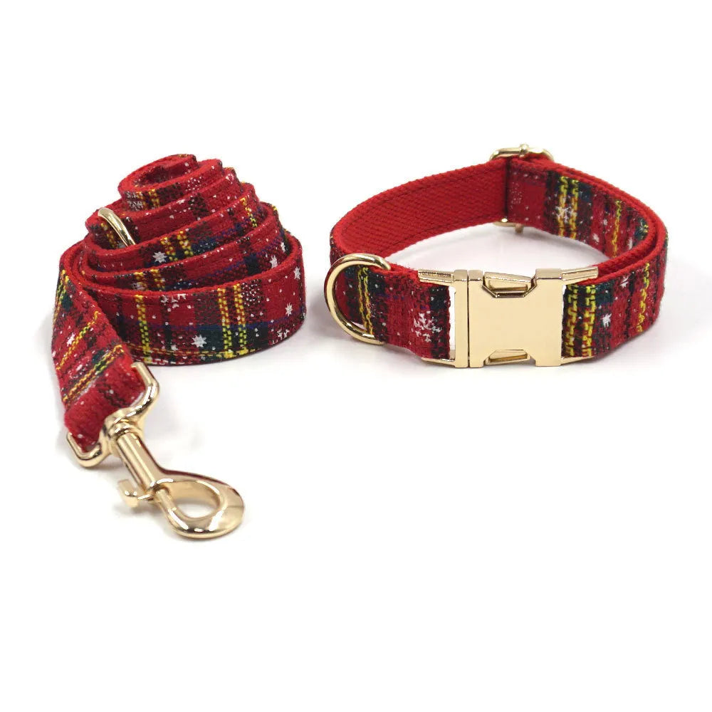 Red Christmas pet collar set with matching harness, leash, bow, and dog waste bag on cloth background