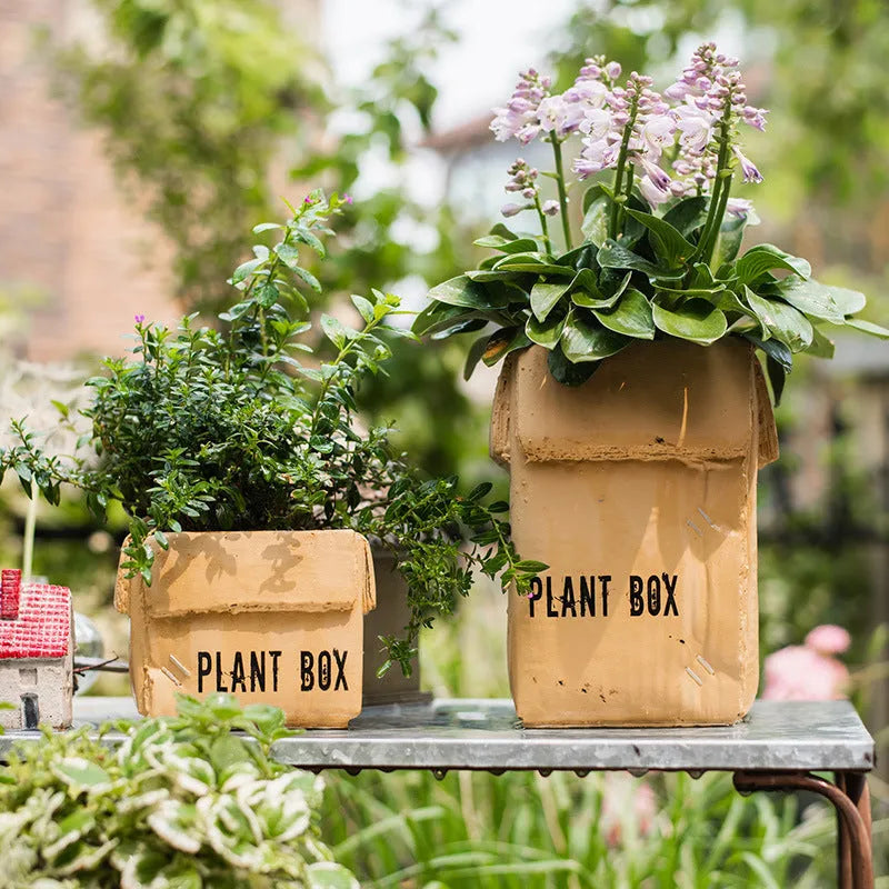 Cement flower pot with brown paper box design showing perforated drainage base