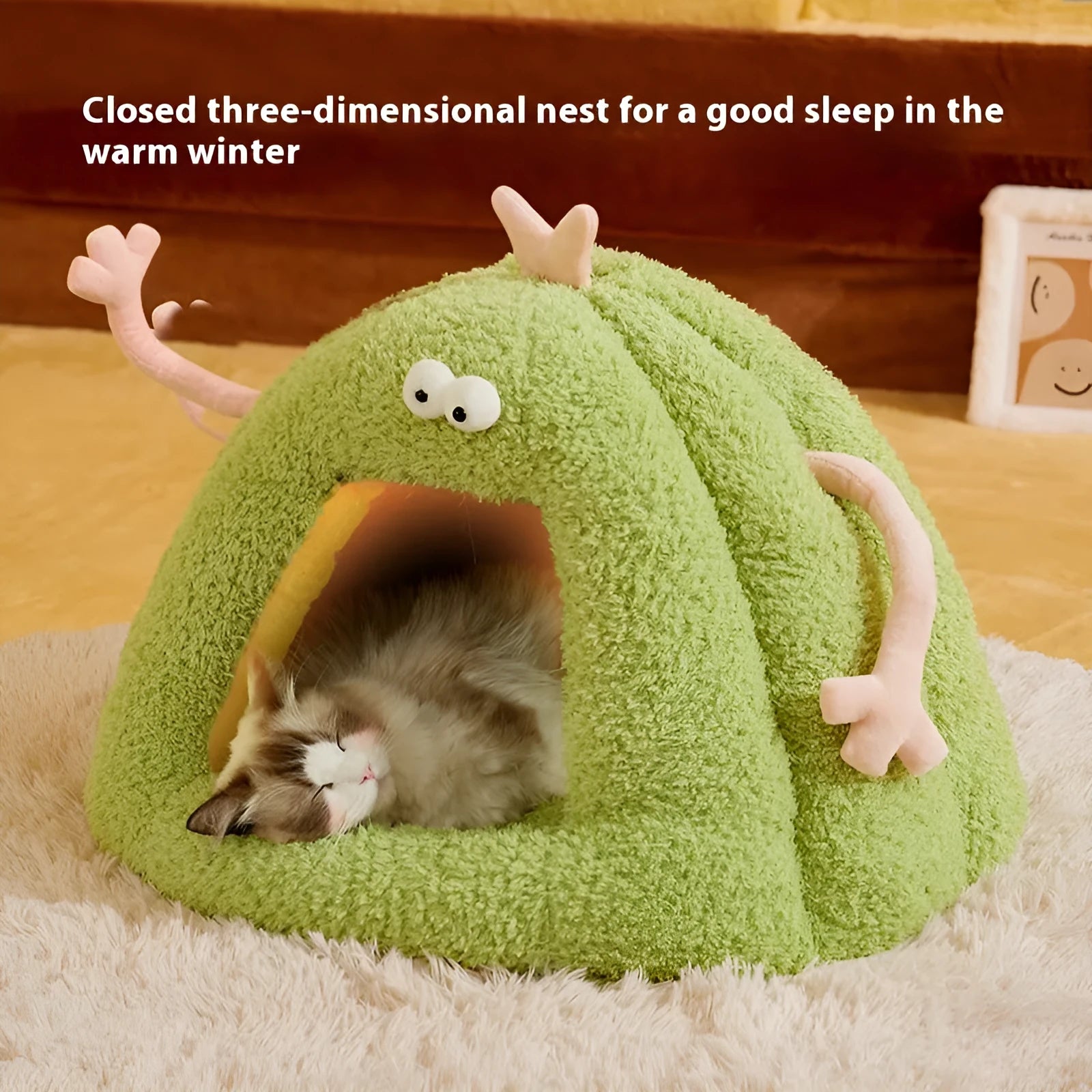 Green monster-shaped semi-enclosed cat kennel bed for small cats on a floor.