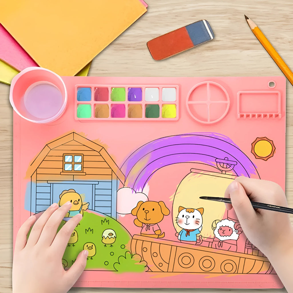 Light blue silicone painting mat with two round bowls, placed on a wooden table with paintbrushes.