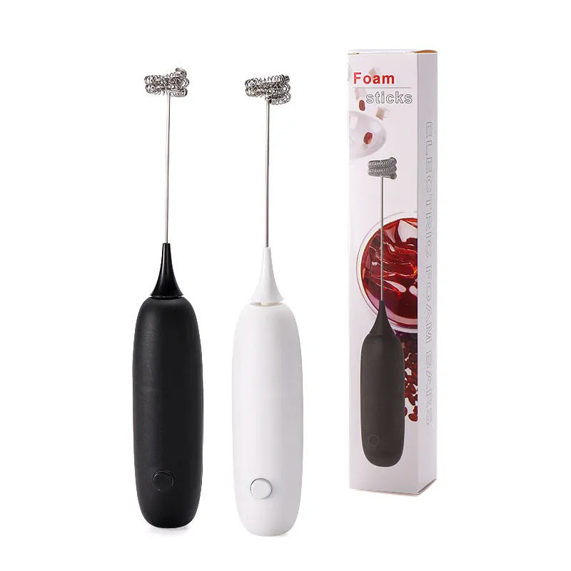 A handheld electric milk frother in black and white colours on a kitchen counter.