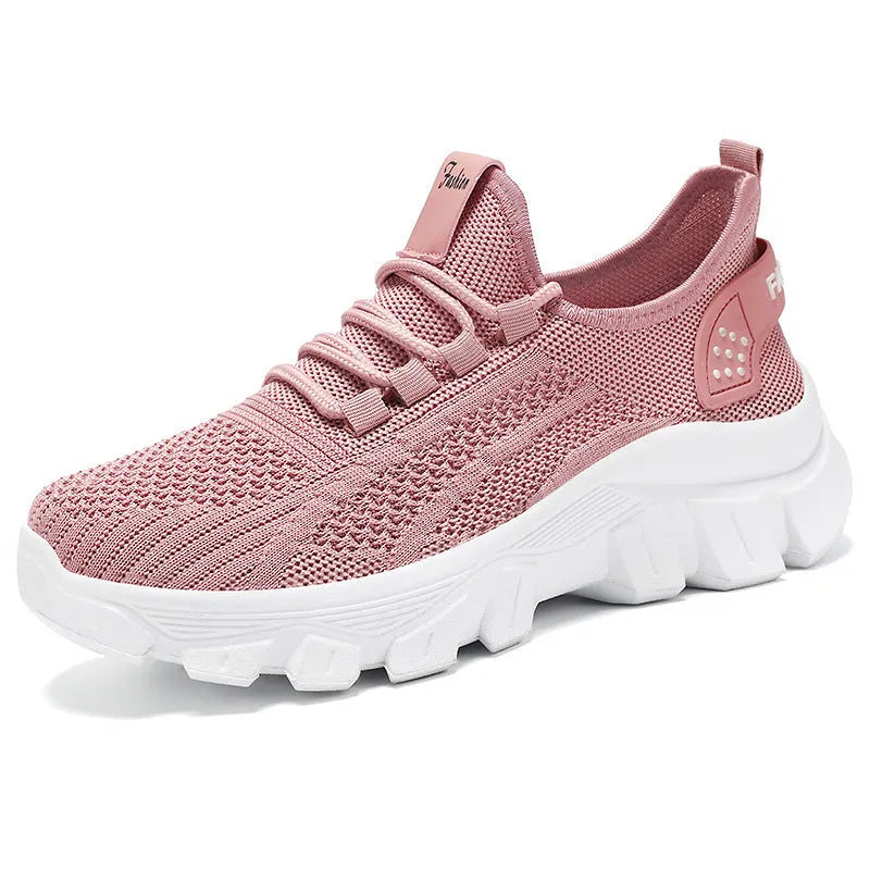 Women's white Flyknit running sneakers with a round toe and flat PVC sole, shown with lace-up front.