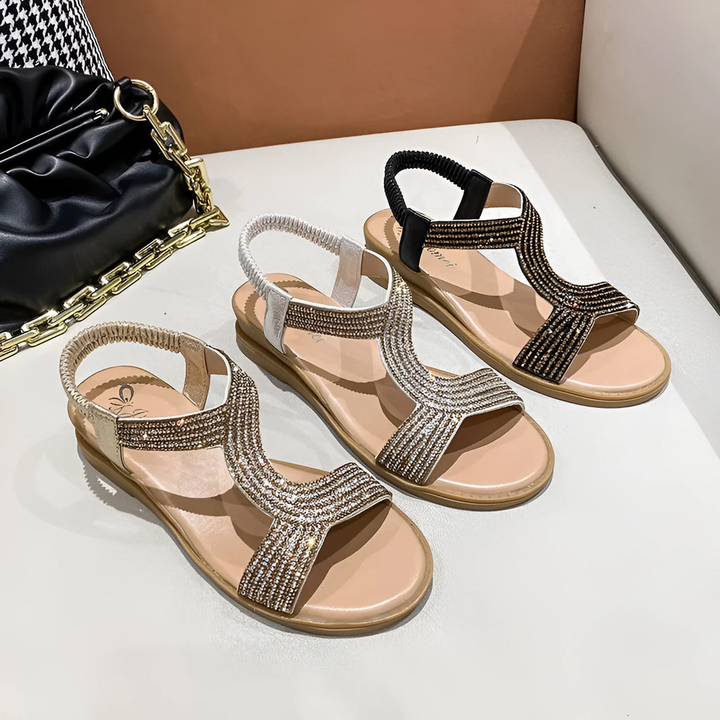 Women's gold patent leather beach sandals with rhinestones on a round toe, showing non-slip sole.