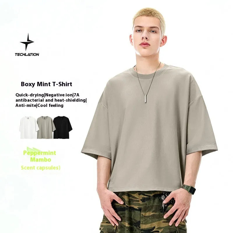 Man wearing a loose-fit Sand Grey short sleeve t-shirt made from cotton-polyester blend.