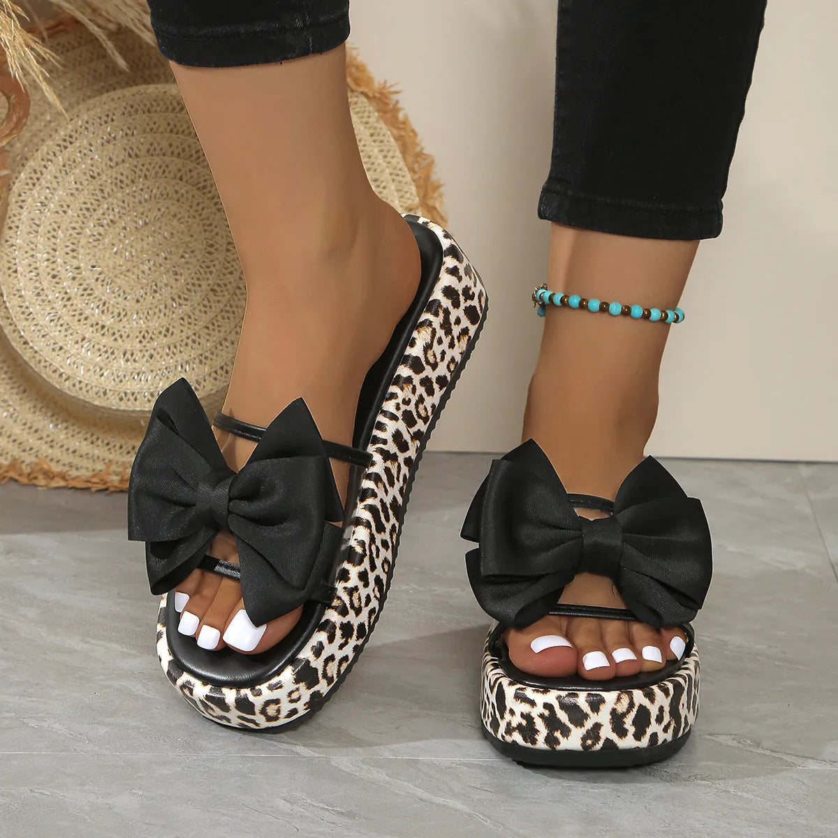 Women's black and white leopard print beach slippers with a thick sole and round toe.