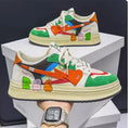 A pair of simple plain lace-up sneakers in a choice of rainbow, white blue, or white rice colours on a white background.