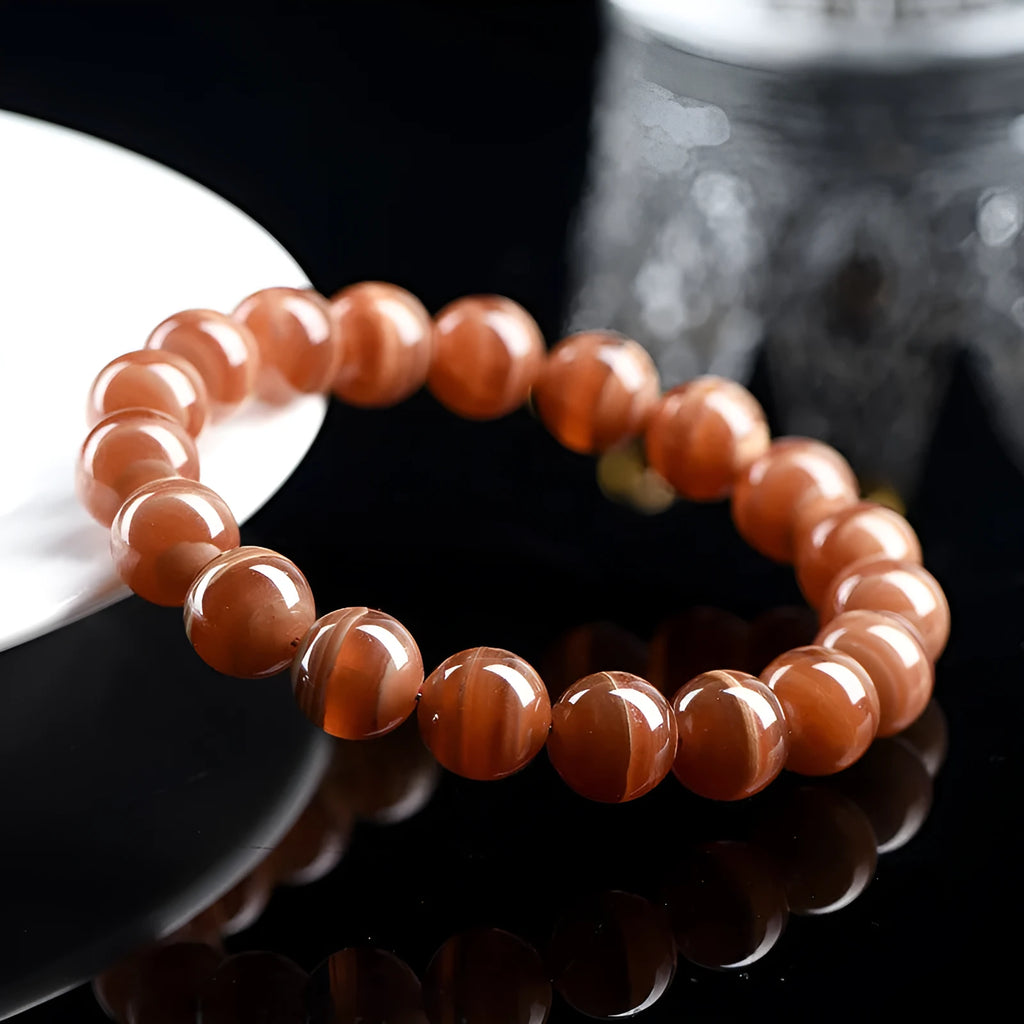 Natural Old Mine Rhodochrosite round bead bracelet with Ruyi design, shown in 6mm and 8mm sizes.