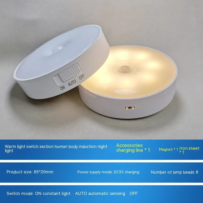 Small white circular motion sensing LED night light with USB charging cable and adhesive tape.