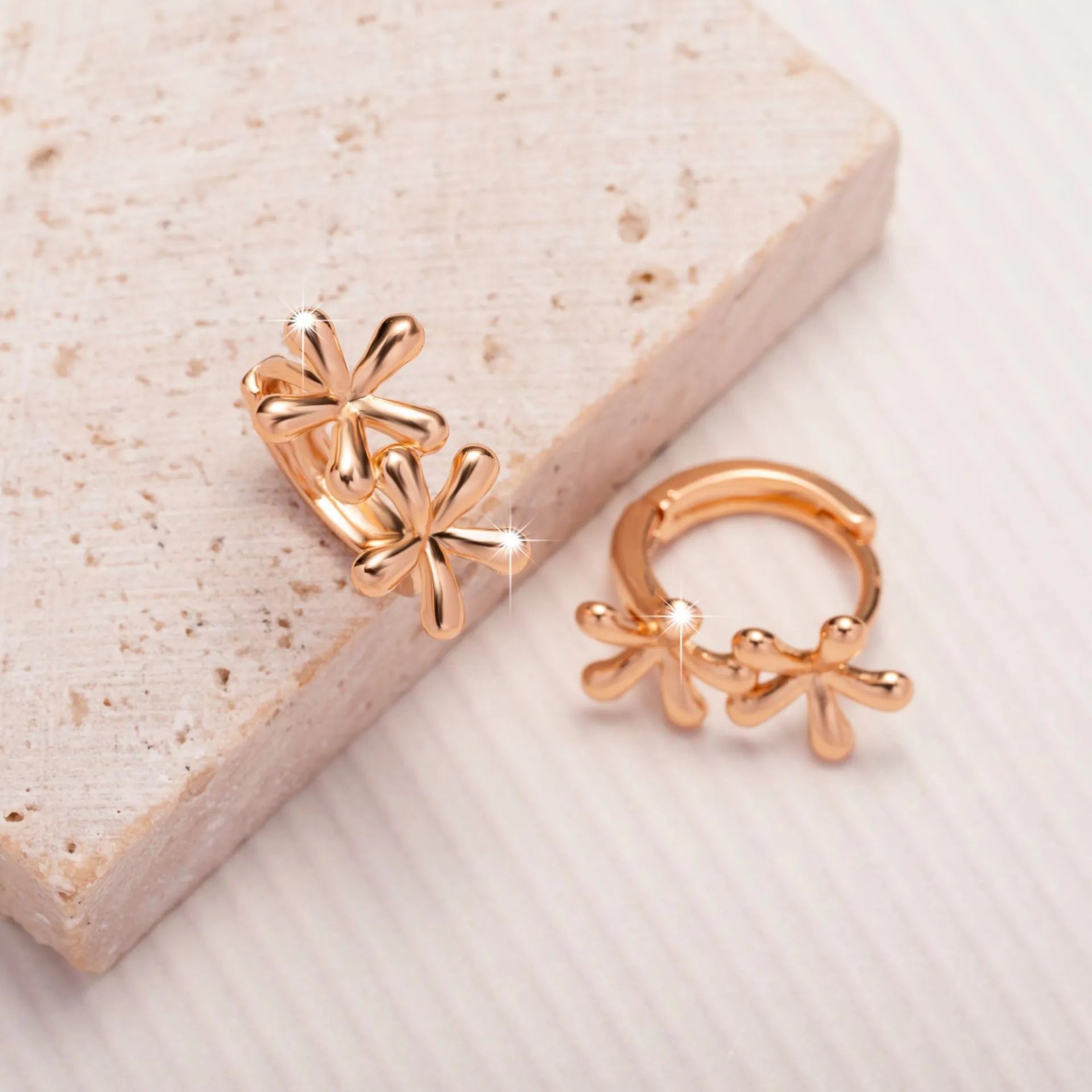 Rose gold waterdrop flower stud earrings with circular floral design on a white background.