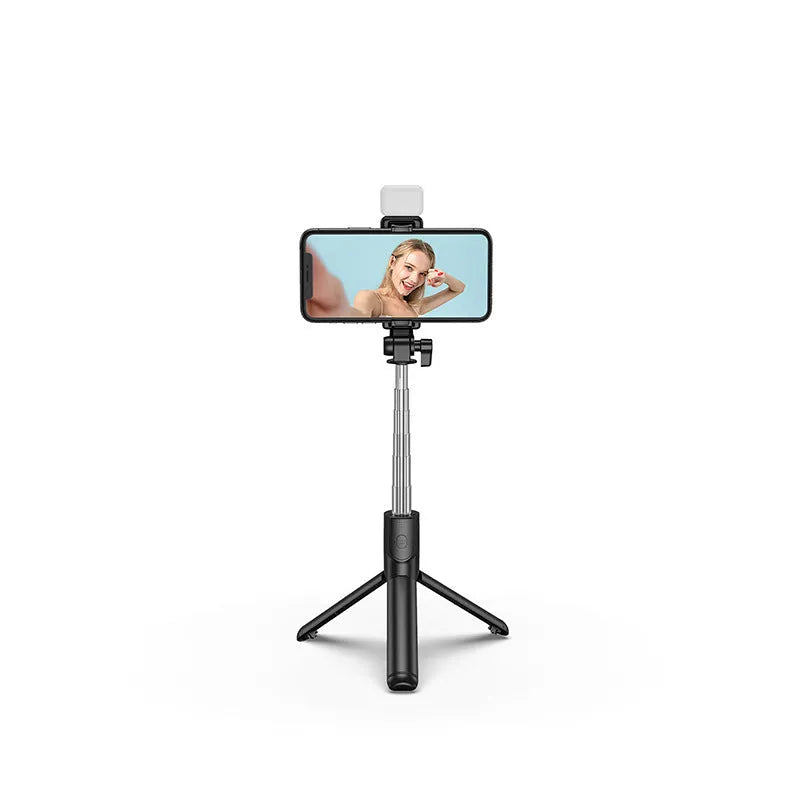 Black Bluetooth selfie stick with fill light and extended tripod legs holding a smartphone.