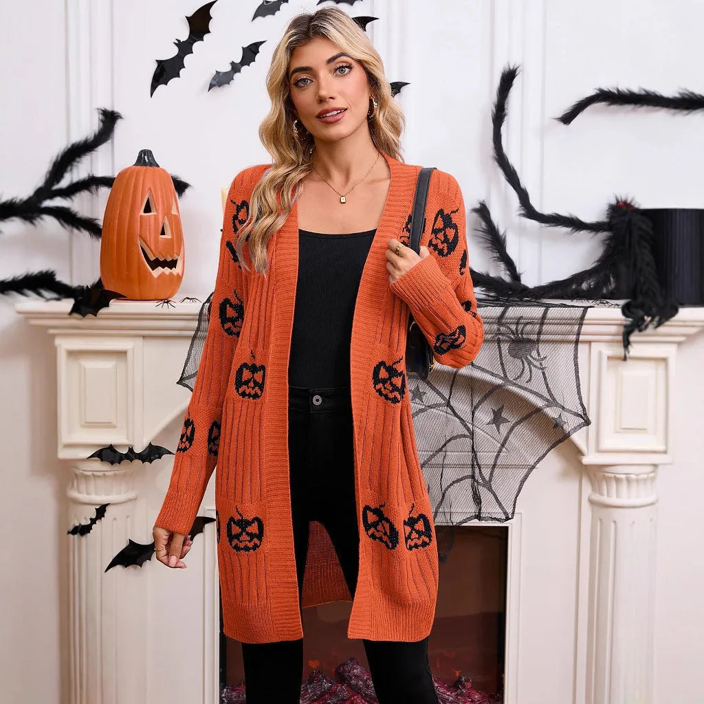 Women's black cardigan with orange pumpkin head jacquard knit pattern, shown as a medium-length coat.