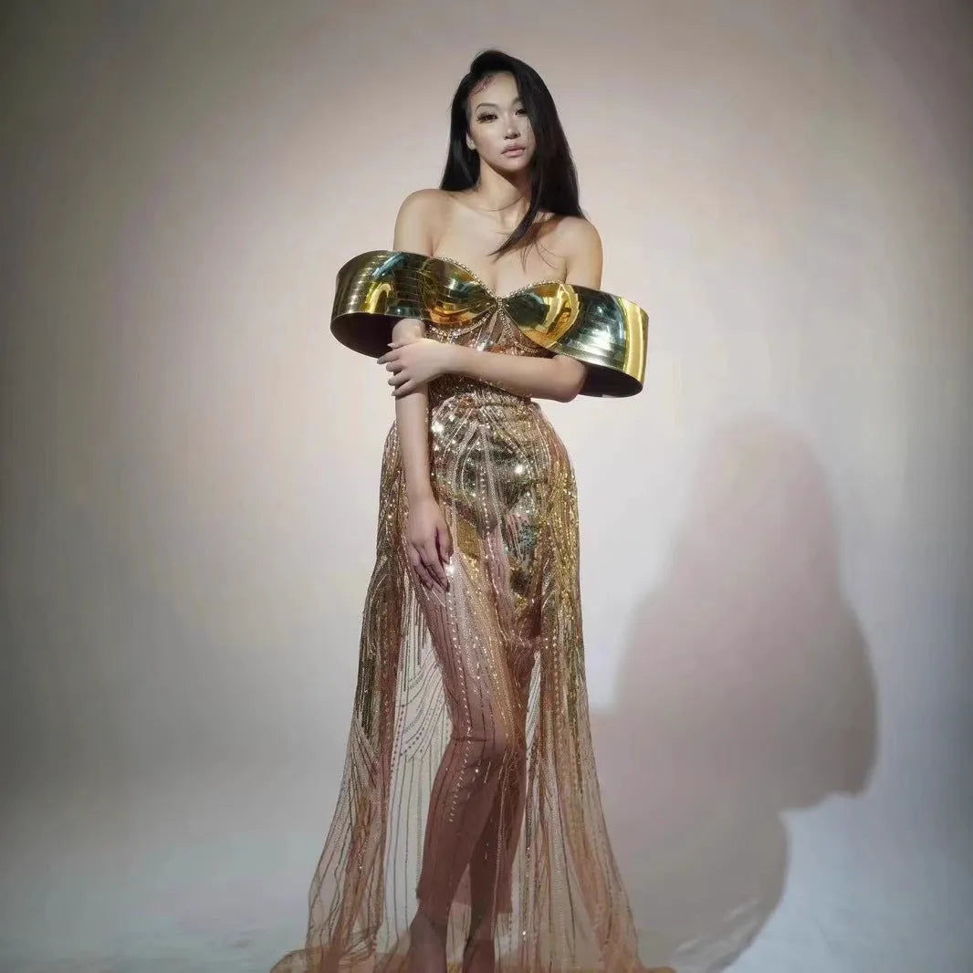 Gold strapless sequin evening dress with a long tulle skirt and thigh split on a mannequin.