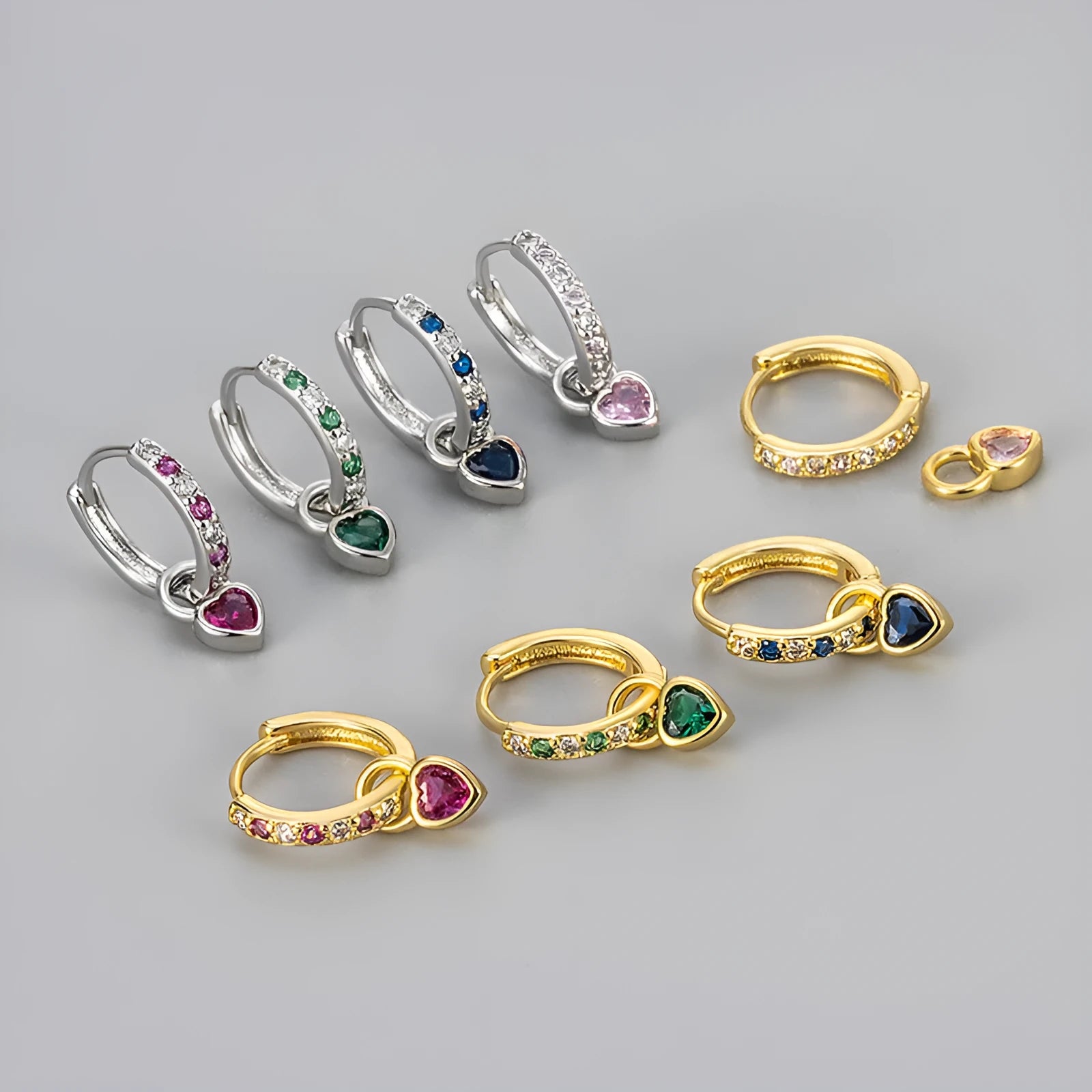 Women's heart-shaped earclip earrings with a coloured zircon or stone centre, in gold or white gold colour.