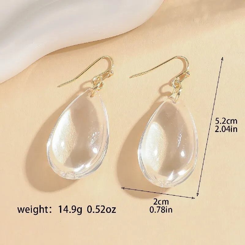 Transparent glass or crystal teardrop drop earrings with irregular shape and cold-tone finish for women