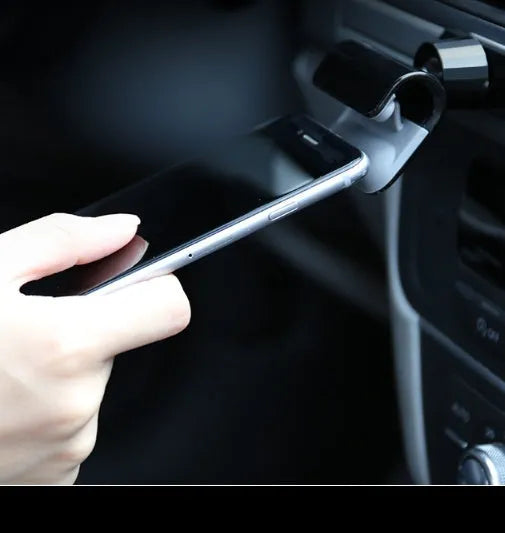 Black car phone holder with 360-degree rotation mounted on vehicle dashboard holding smartphone