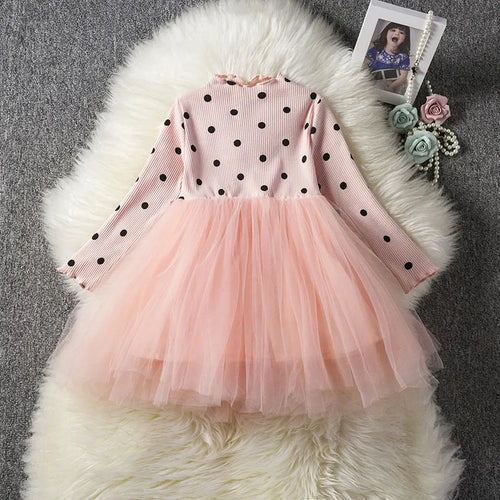 Baby girl wearing a long sleeve black tutu lace dress for a first birthday or christening event.