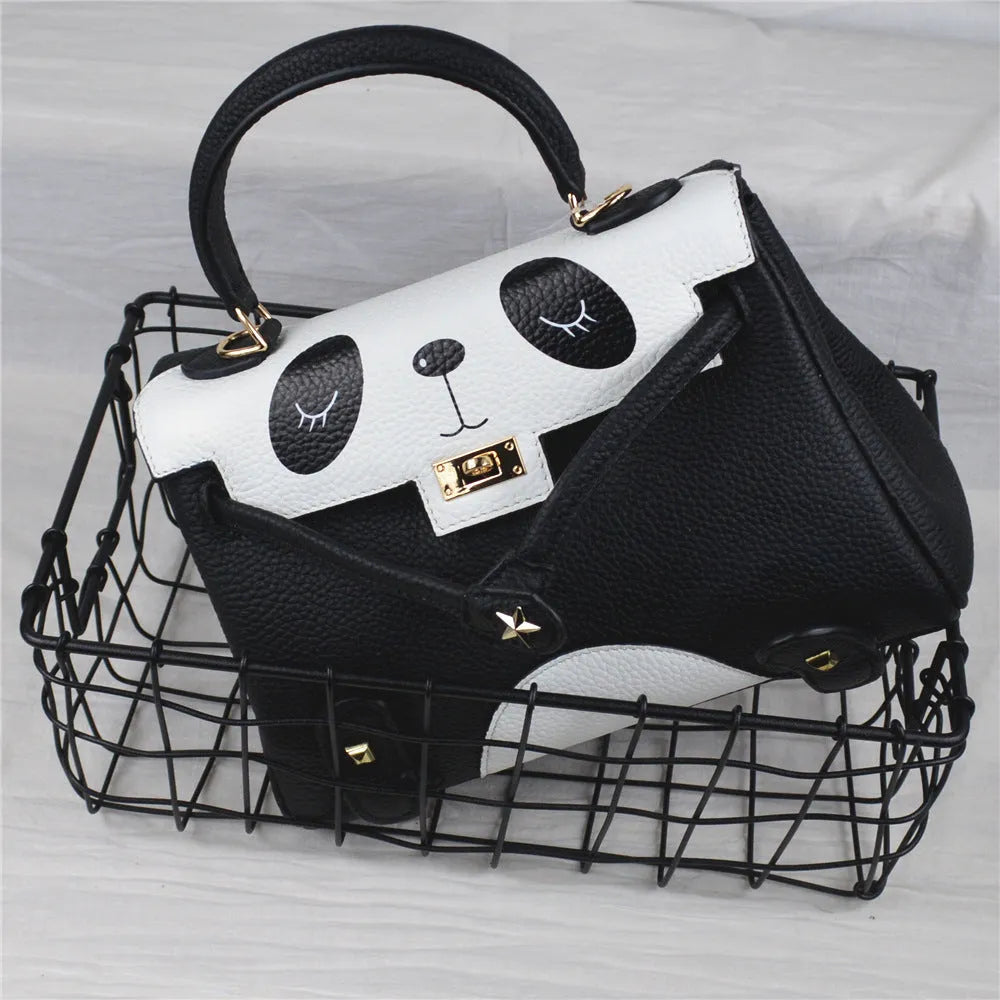 Black and white panda print on a structured horizontal square cowhide leather handbag with a trumpet detail.