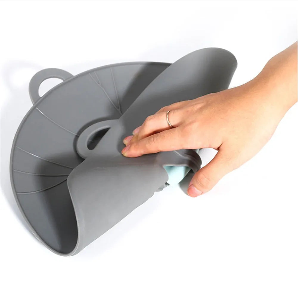 Silicone spill-proof pot cover in black, size 30x26cm, resting on a pot