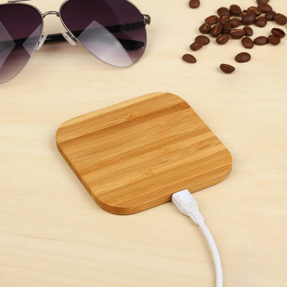 Square wooden bamboo 5W wireless charging pad on a table.